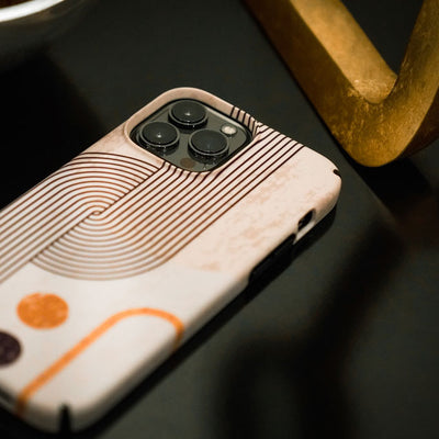 Close-up of an iPhone with the Presidio Edition: Bold Bauhaus Collection case on it laying face down next to some furniture