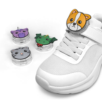 Three-quarter angled view of a white child's shoe with Tagimal Milo attached, with other Tagimals Mittens, Tink, and Blaze lying next to the shoe#color_blaze-milo-mittens-and-tink