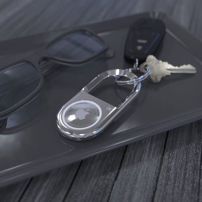 Set of keys sitting on a table next to sunglasses with Carabiner for AirTag attached