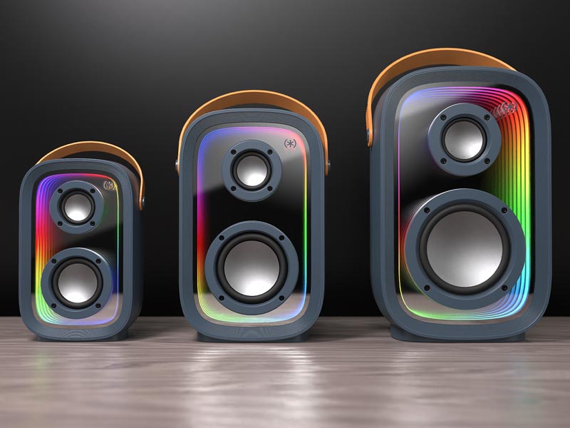 The three sizes of Gemtones Infinity Speakers - Mini, Mid, and Max - sit on a wood table with rainbow light show activated