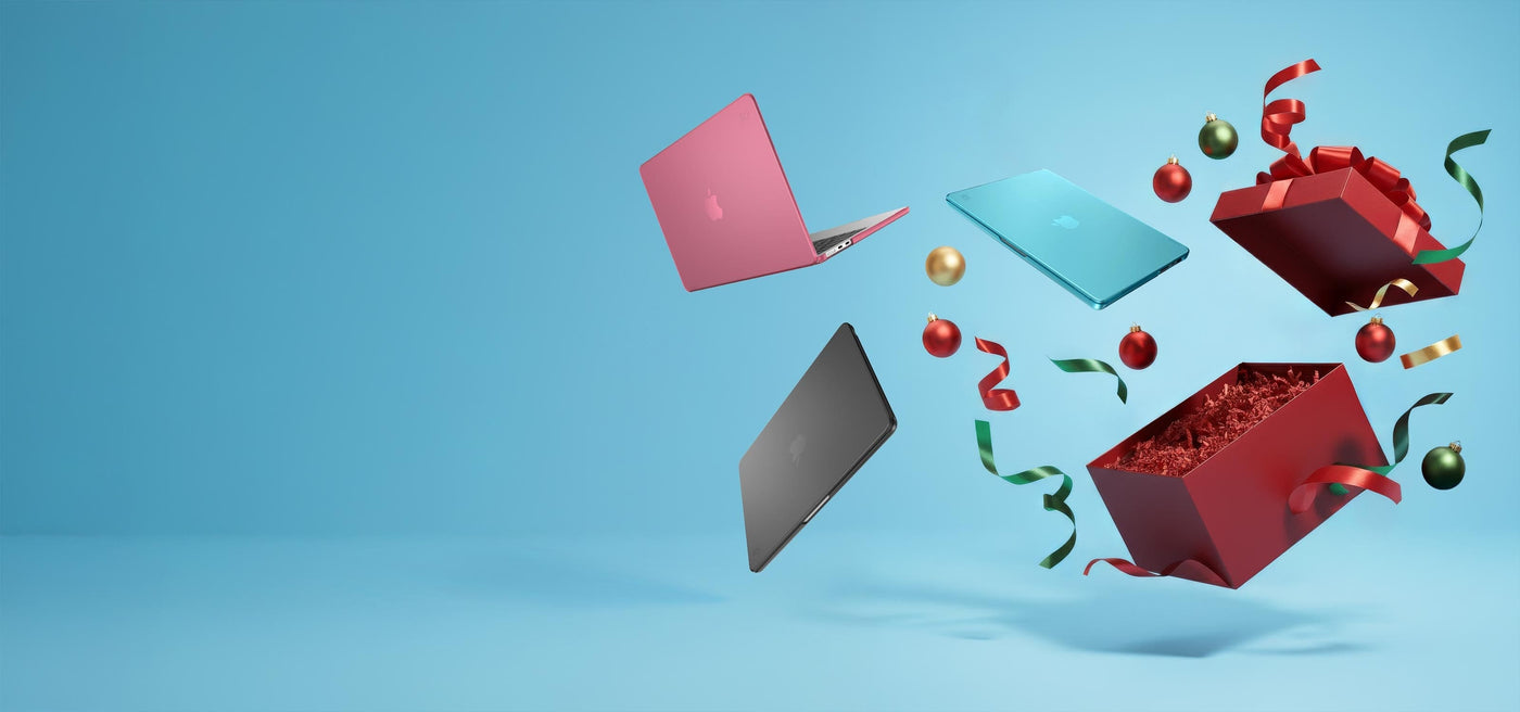 Three MacBooks in Speck cases fly out of a Christmas box along with ornaments and ribbon