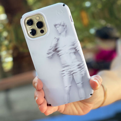 A hand holding an iPhone with the Presidio Edition: Motions In Marble Collection case on it
