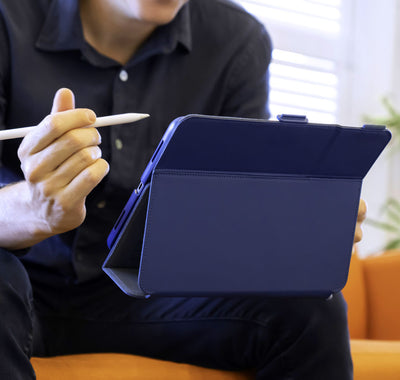 Man holding an iPad with Speck Balance Folio case on it while sitting on a couch