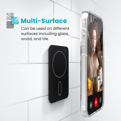 Phone in a clear case hovering above an Everywhere Mount attached to a tile surface. Text reads Multi-Surface - Can be used on different surfaces including glass, wood, and tile#color_black-slate-grey