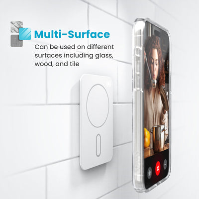 Phone in a clear case hovering above an Everywhere Mount attached to a tile surface. Text reads Multi-Surface - Can be used on different surfaces including glass, wood, and tile#color_chantilly-white-serene-silver