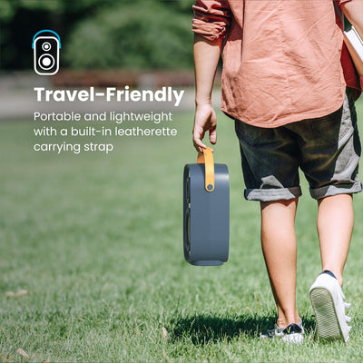 A man walking across grass carries a Gemtones Infinity speaker by the handle. Travel friendly - portable and lightweight with a built-in leatherette carrying strap#color_dark-grey-chrome-tan