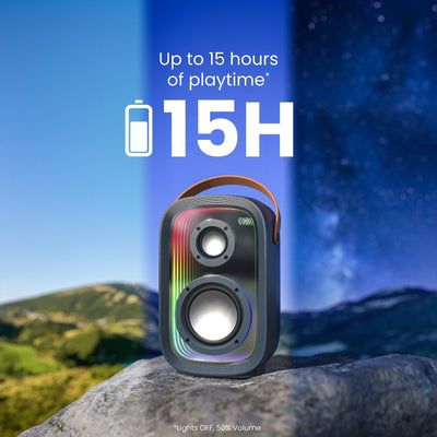 Front view of speaker sitting on a rock with visible time passage in the sky behind it. Up to 15 hours of playtime (Lights OFF, 50% Volume)#color_dark-grey-chrome-tan