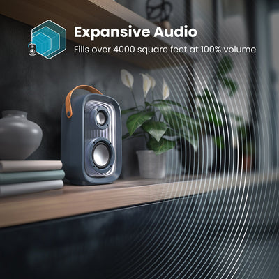 A Gemtones Infinity speaker sits on a shelf with sound waves emanating from it. Expansive audio - fills over 4000 square feet at 100% volume#color_dark-grey-chrome-tan