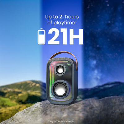 Front view of speaker sitting on a rock with visible time passage in the sky behind it. Up to 21 hours of playtime (Lights OFF, 50% Volume)#color_dark-grey-chrome-tan