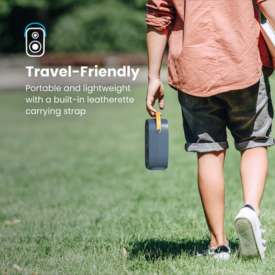 A man walking across grass carries a Gemtones Infinity speaker by the handle. Travel friendly - portable and lightweight with a built-in leatherette carrying strap#color_dark-grey-chrome-tan